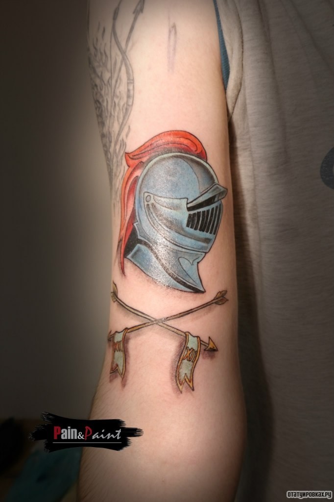 Фотография татуировки под названием «Шлем гладиатора и две стрелы»