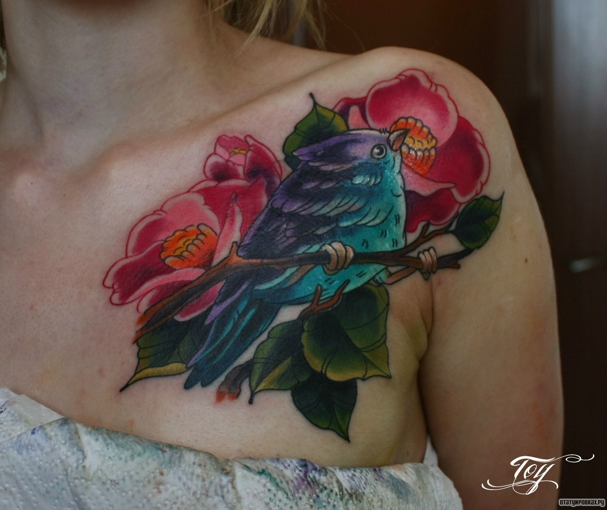 Фотография татуировки под названием «Птичка с цветами на ветке»