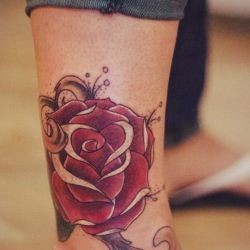 Красная роза на голени девушки