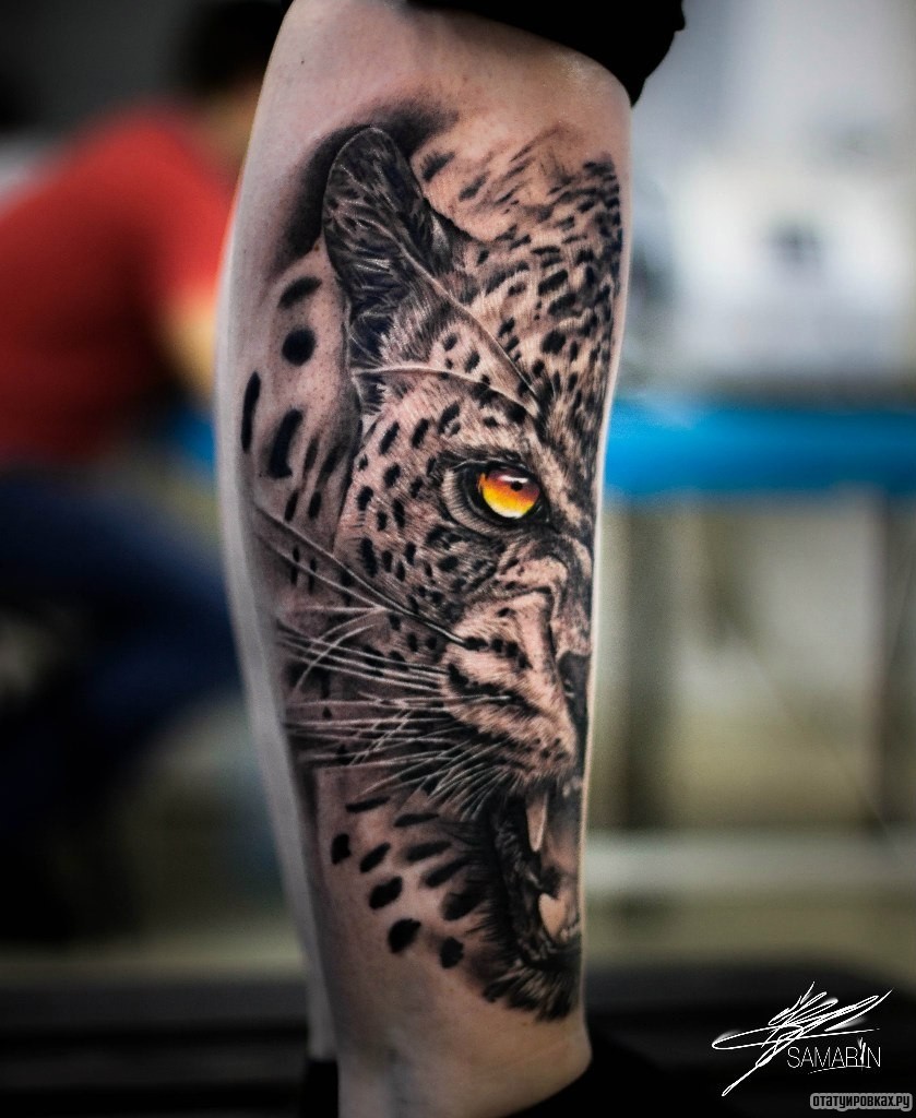Фотография татуировки под названием «Половина морды тигра с оранжевыми глазами на голени»