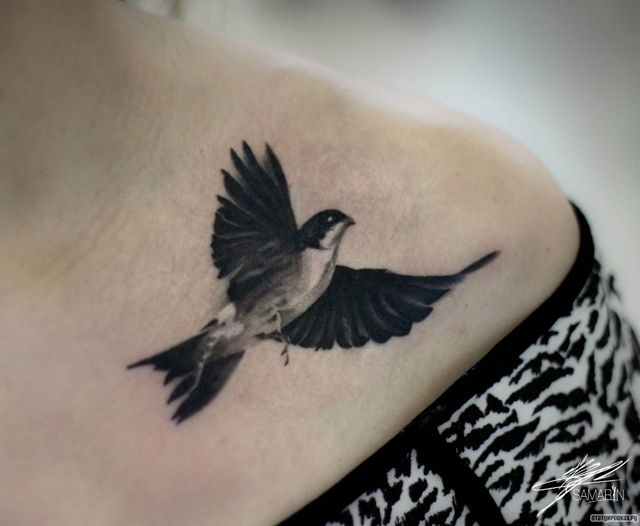 Фотография татуировки под названием «Птица в полете на груди девушки»