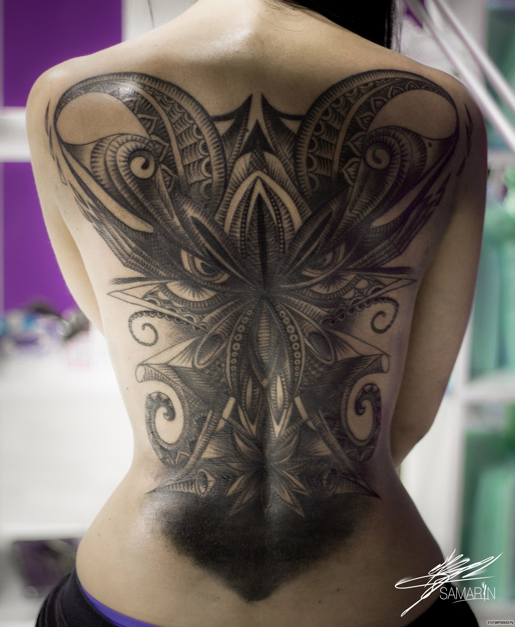 Фотография татуировки под названием «Узор лица на спине девушки»
