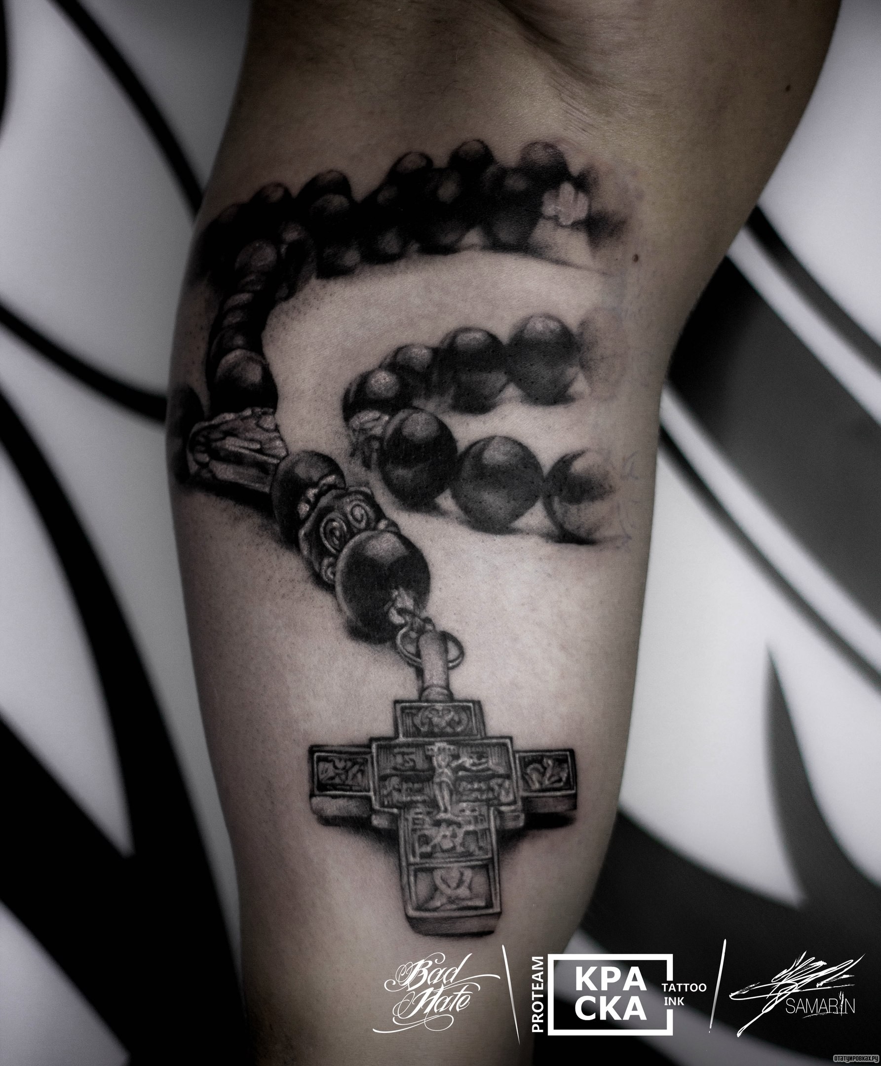 Фотография татуировки под названием «Крест с цепочкой на бицепсе парня»
