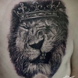 Тату ухмылка льва в короне на груди