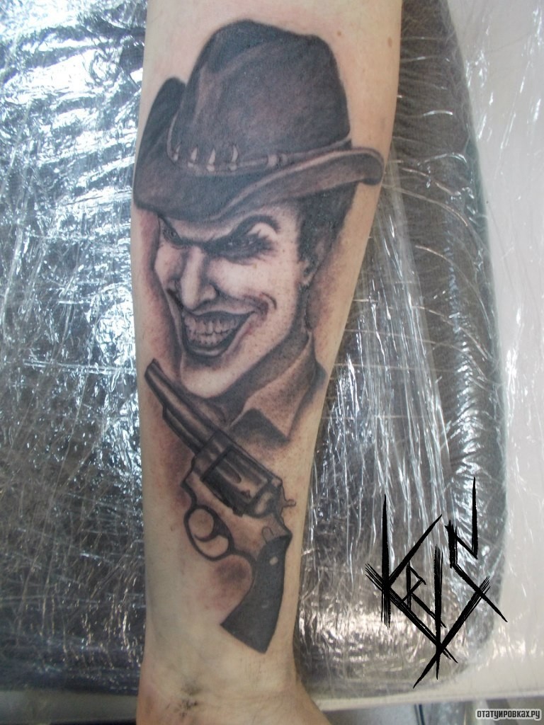 Фотография татуировки под названием «Клоун и пистолет на голени»
