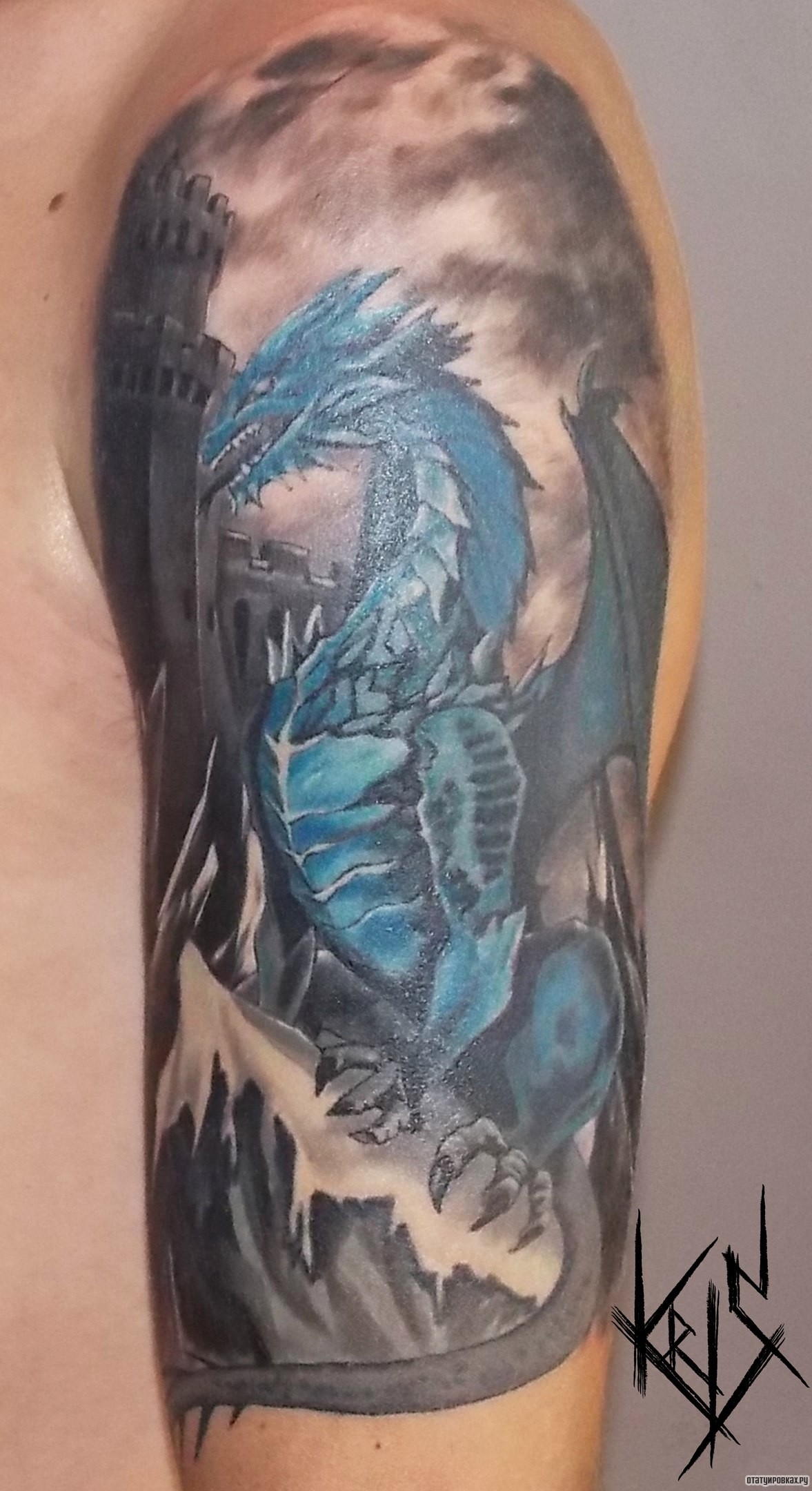 Фотография татуировки под названием «Бирюзовый дракон на фоне замка, тату на плече»
