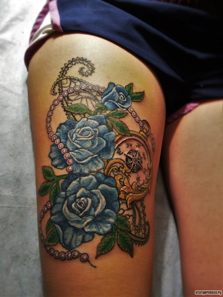 Фотография татуировки под названием «Три синих розы и часы с украшением на бедре»