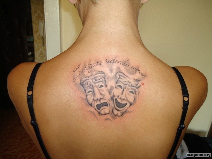 Фотография татуировки под названием «Две маски и надпись на спине»