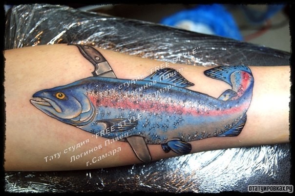 Фотография татуировки под названием «Рыба, пронизанная ножом на предплечье»