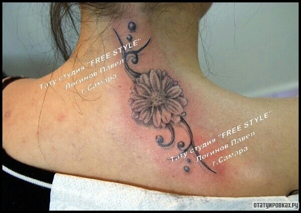 Фотография татуировки под названием «Цветок и узор на спине девушки»
