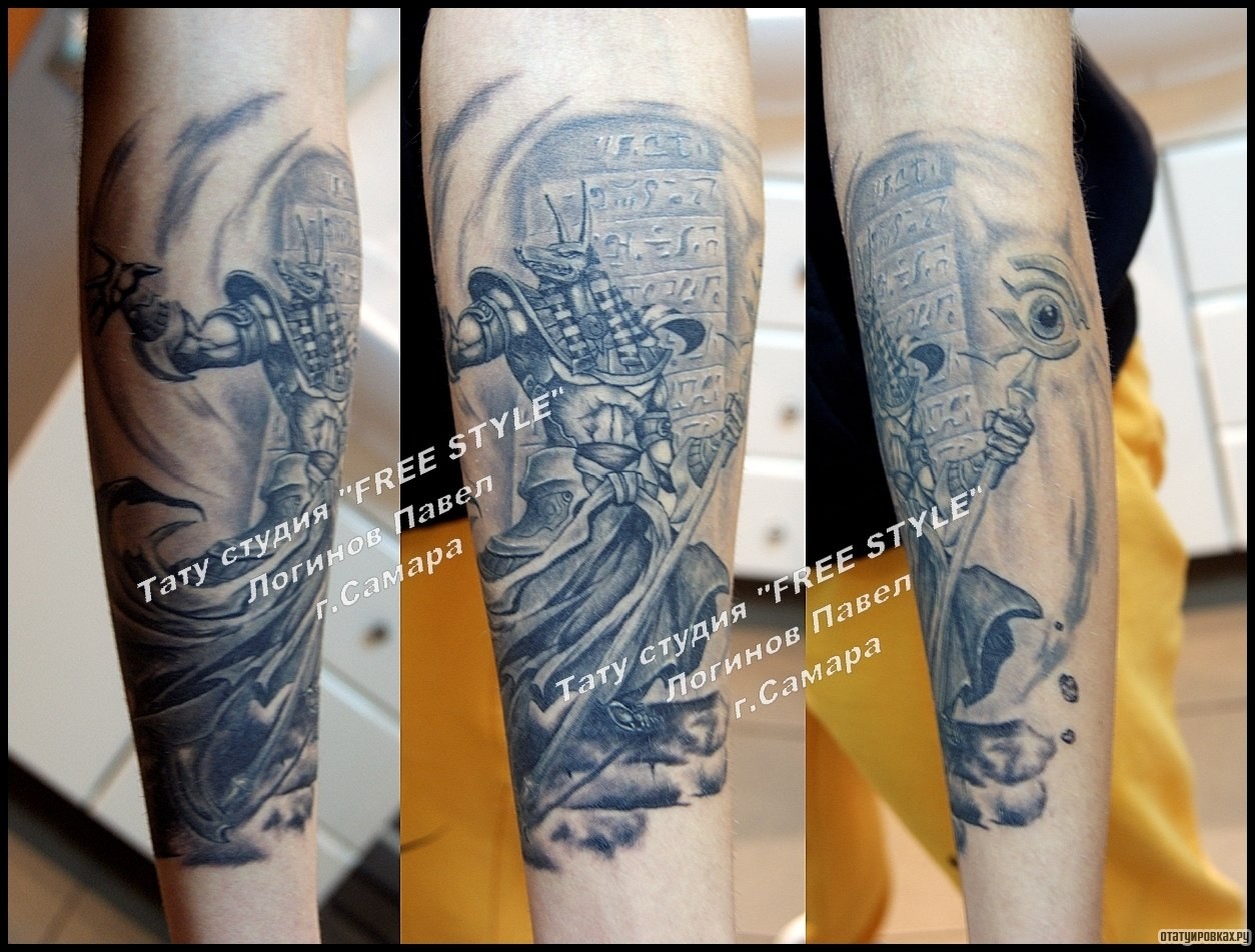 Фотография татуировки под названием «Анубис на фоне рун, тату на предплечье»