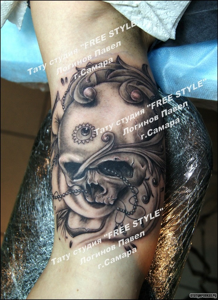 Фотография татуировки под названием «Череп в украшениях на бицепсе»