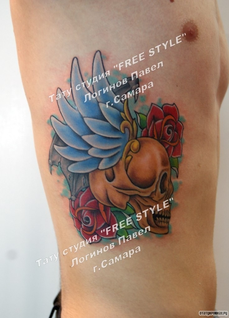 Фотография татуировки под названием «Череп с крыльями и розами сбоку тела»