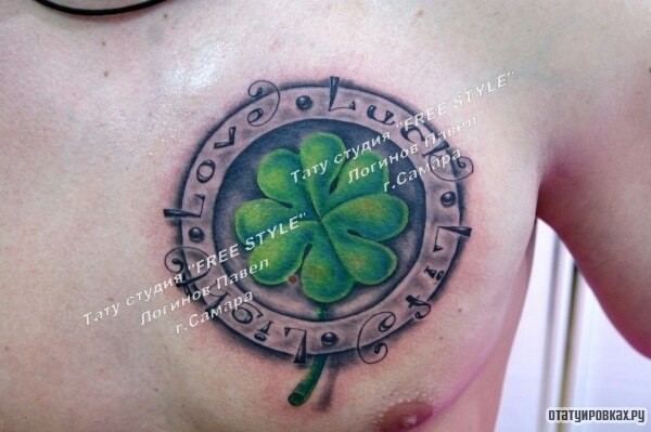 Фотография татуировки под названием «Клевер в круге с надписью lucky на груди»