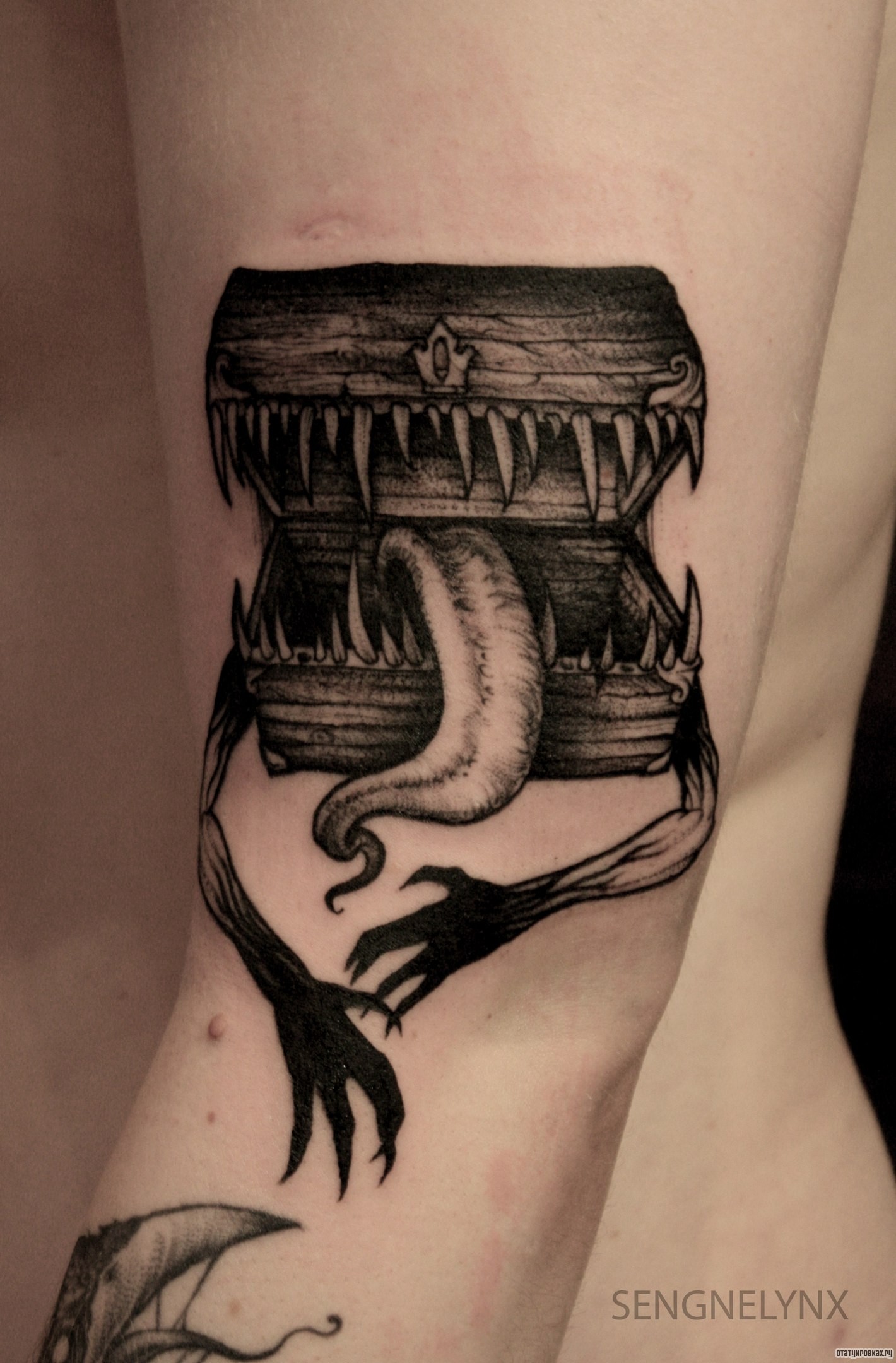 Фотография татуировки под названием «Сундук с языком и руками»