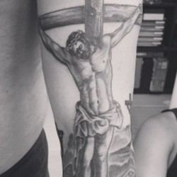 Распятый Иисус на кресте на предплечье, на плече