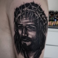Иисус в темном исполнении на плече