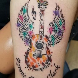 Гитара с крыльями и надписью на плече