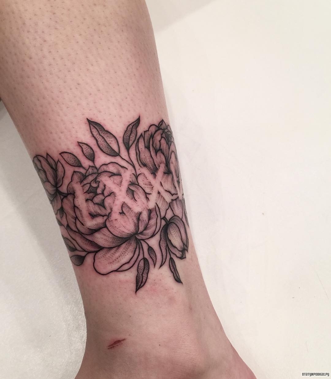 Фотография татуировки под названием «Браслет в виде роз с надписью»