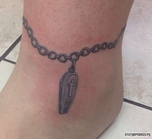 Фотография татуировки под названием «Оберег в виде гроба на цепочке»