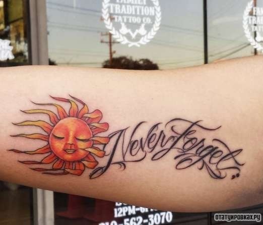 Фотография татуировки под названием «Оранжевое солнце и надпись»