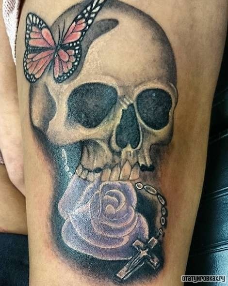 Фотография татуировки под названием «Череп с бабочкой, сиреневой розой и крестиком»
