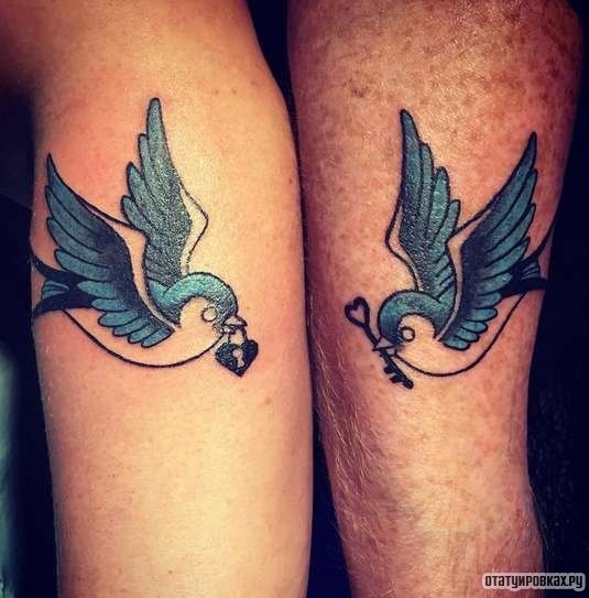 Фотография татуировки под названием «Две ласточки с ключиком и замком в клюве»