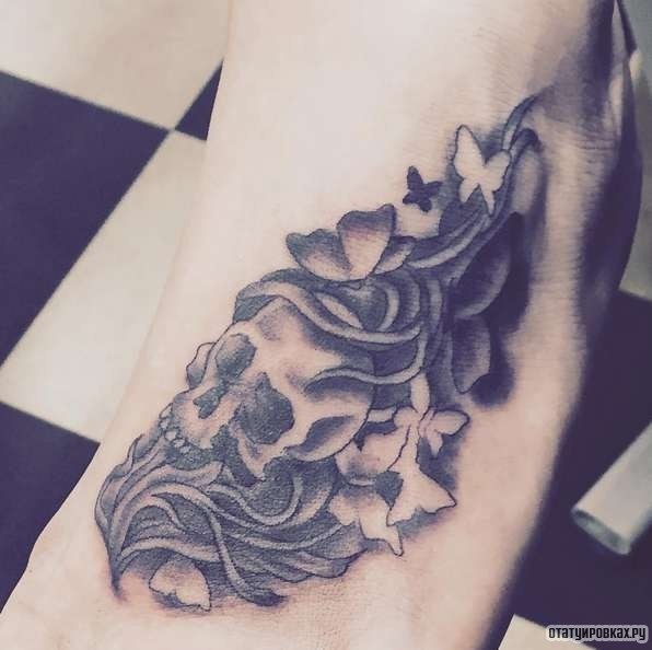 Фотография татуировки под названием «Череп в цветах и траве»