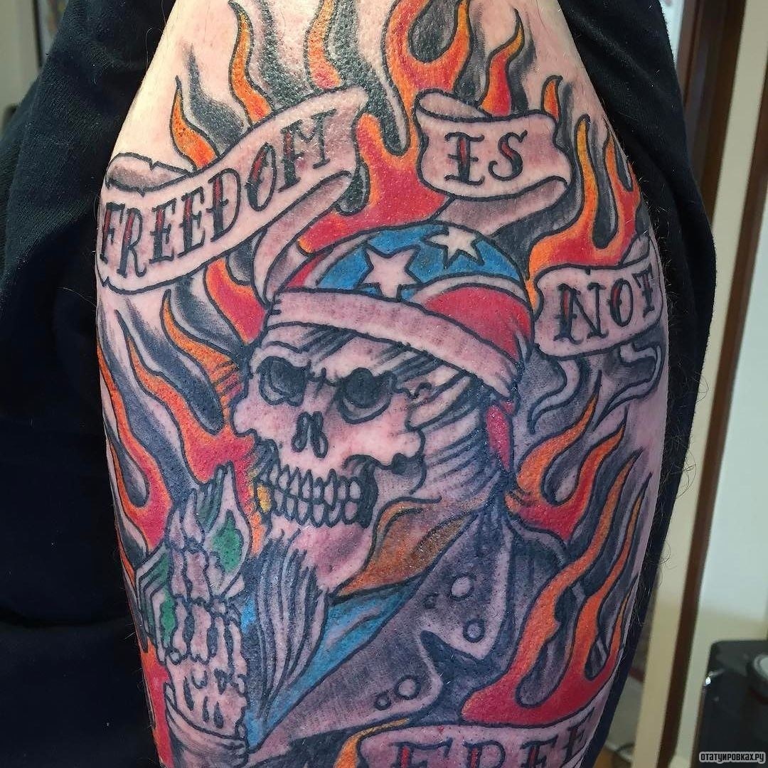 Фотография татуировки под названием «Скелет в огне с лентами и надписью»