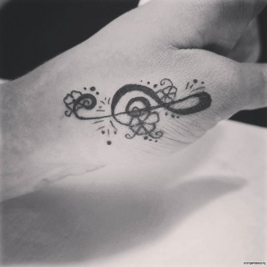Фотография татуировки под названием «Скрипичный ключ с цветами»