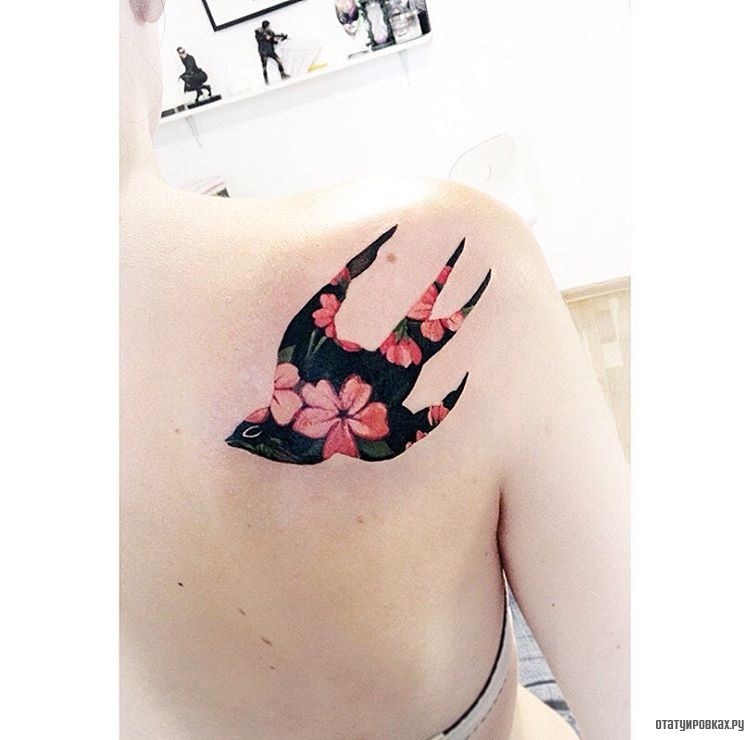 Фотография татуировки под названием «Очертание ласточки с цветами»