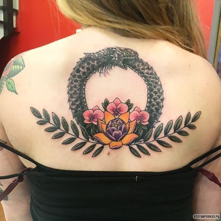 Фотография татуировки под названием «Уроборос с цветами и лотосом»