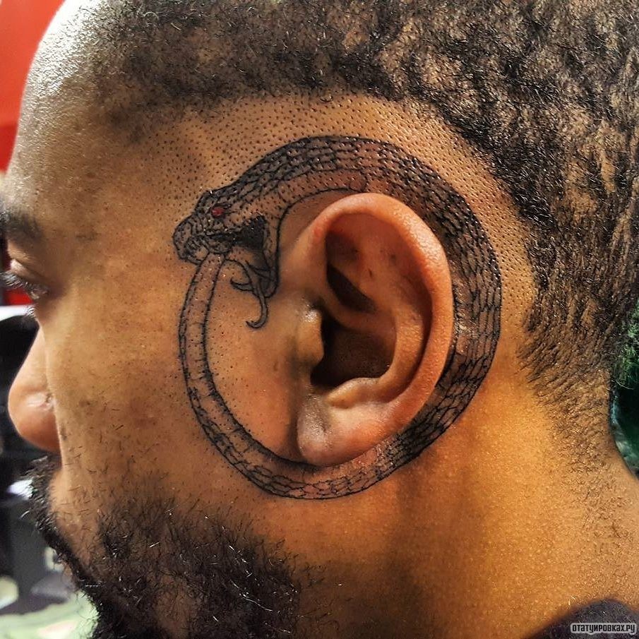 Фотография татуировки под названием «Уроборос вокруг уха»