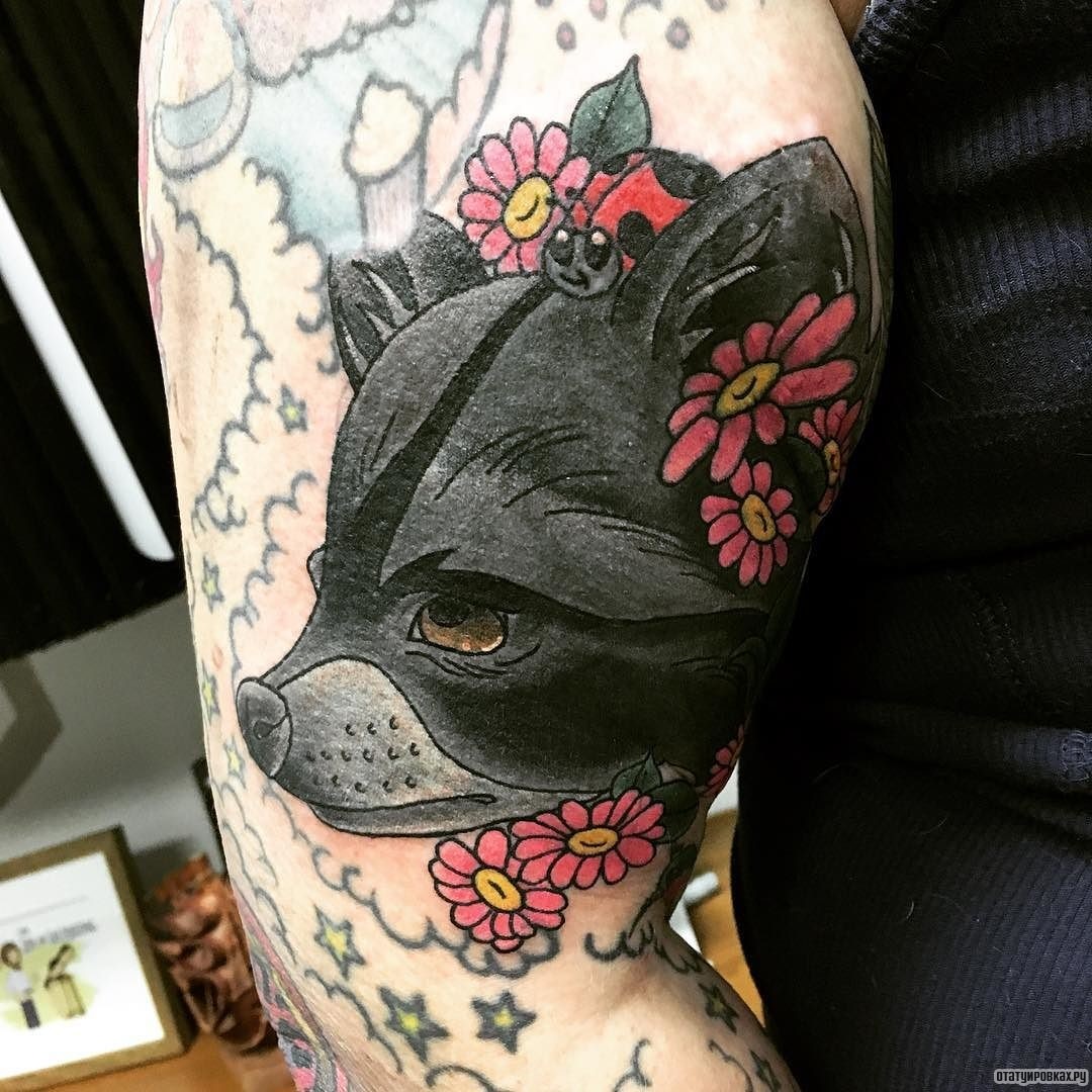 Фотография татуировки под названием «Черный енот в цветах»