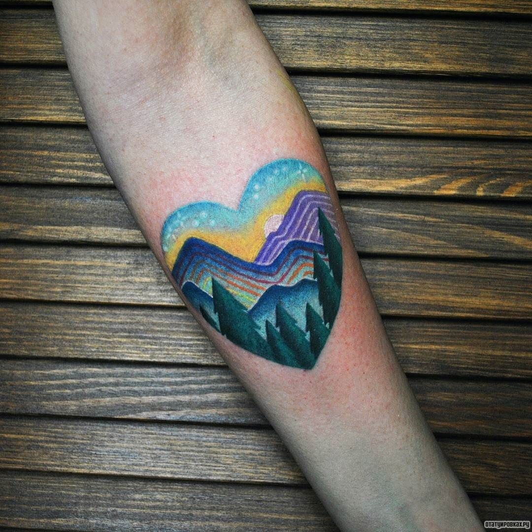 Фотография татуировки под названием «Горы с елками в сердце»