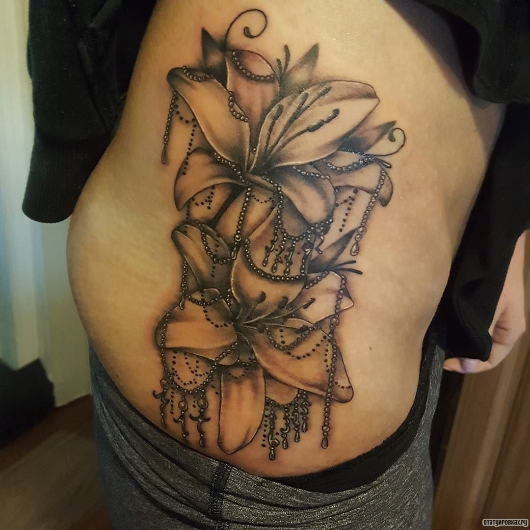 Фотография татуировки под названием «Лилии с украшениями»