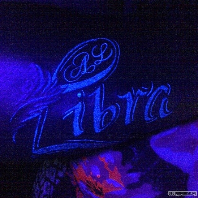 Фотография татуировки под названием «Светящаяся надпись libra»