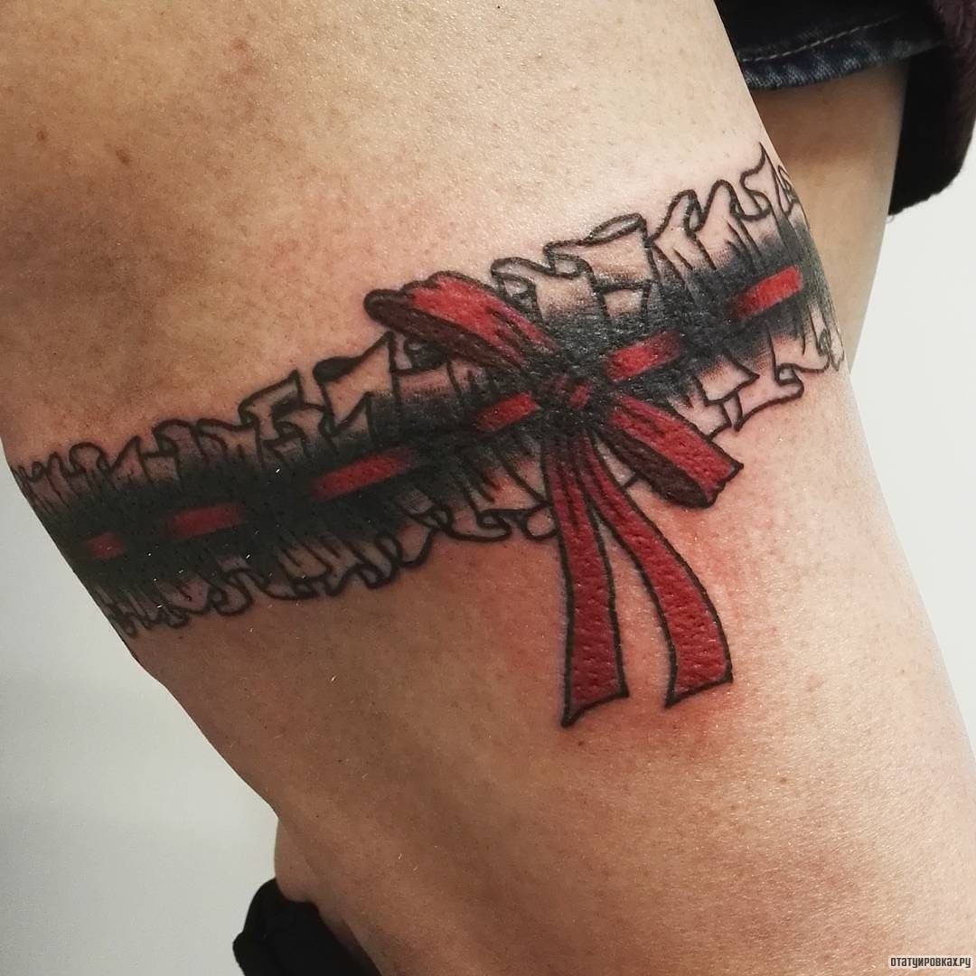 Фотография татуировки под названием «Подвязка с красным бантом»