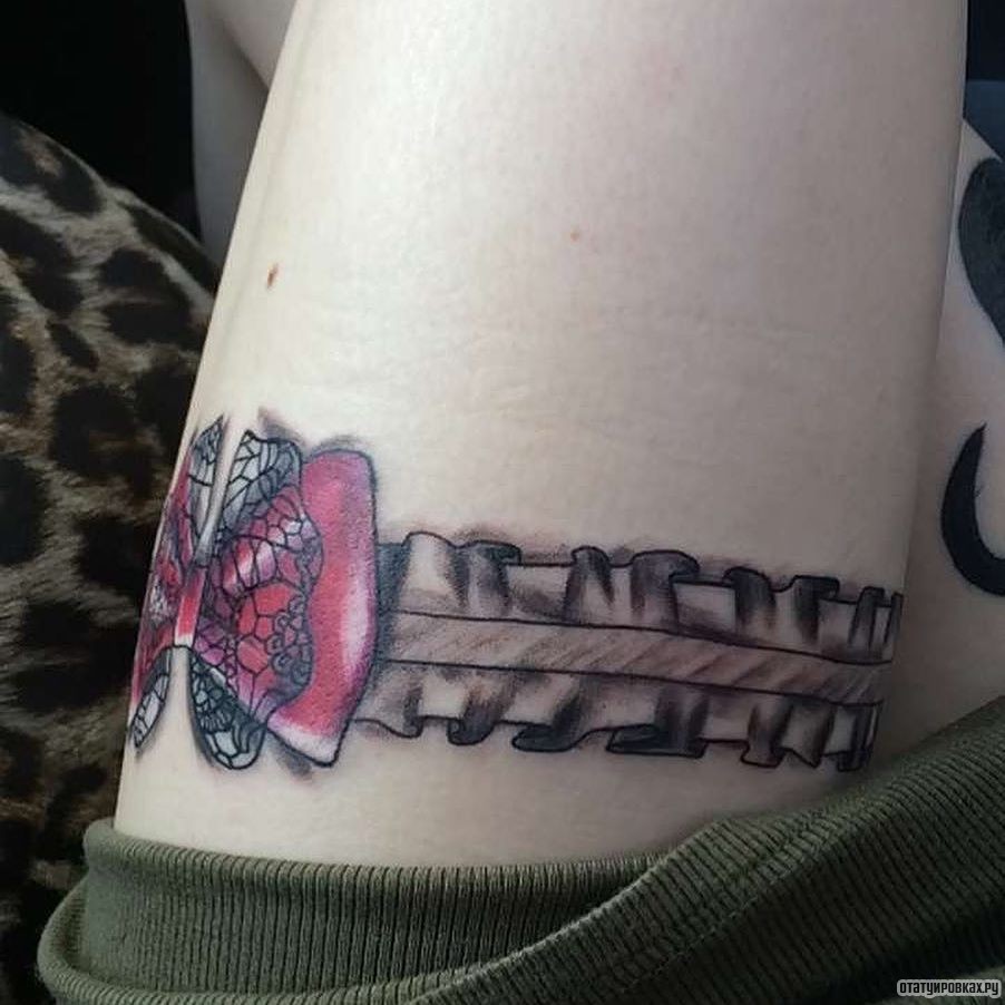 Фотография татуировки под названием «Подвязка и красный бант»