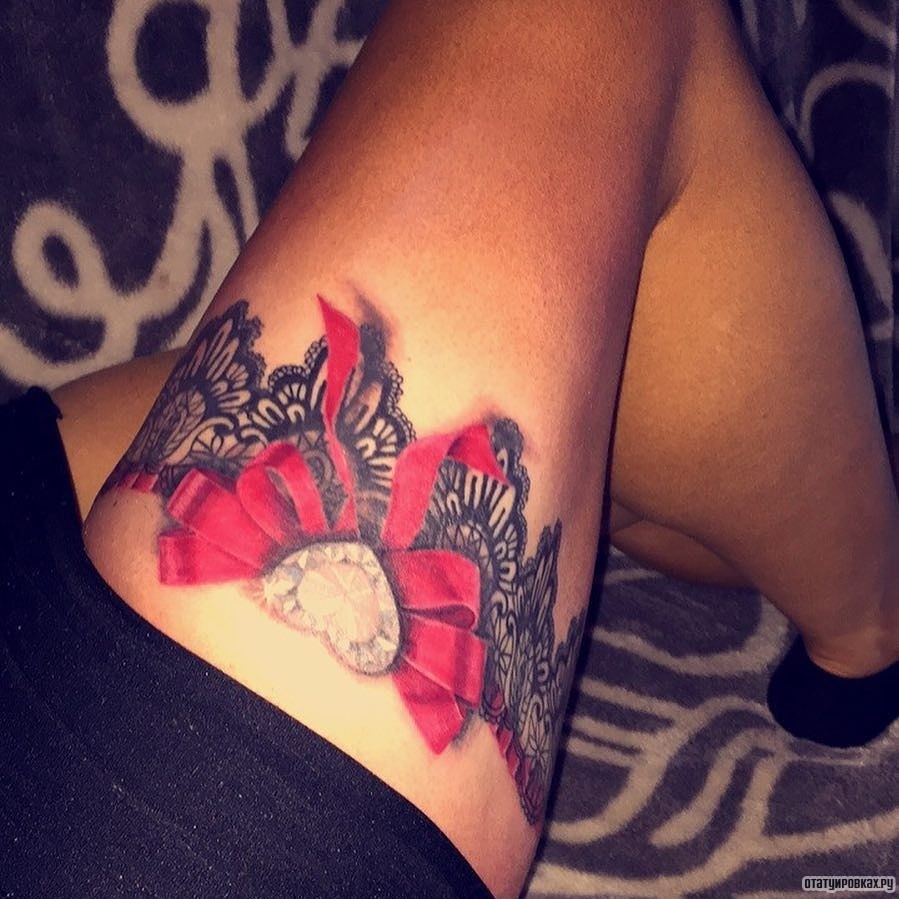 Фотография татуировки под названием «Подвязка и красивый красный бант с алмазом»