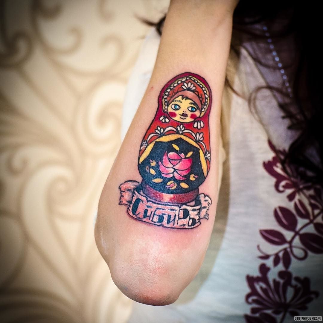 Фотография татуировки под названием «Матрешка и надпись сибирь»