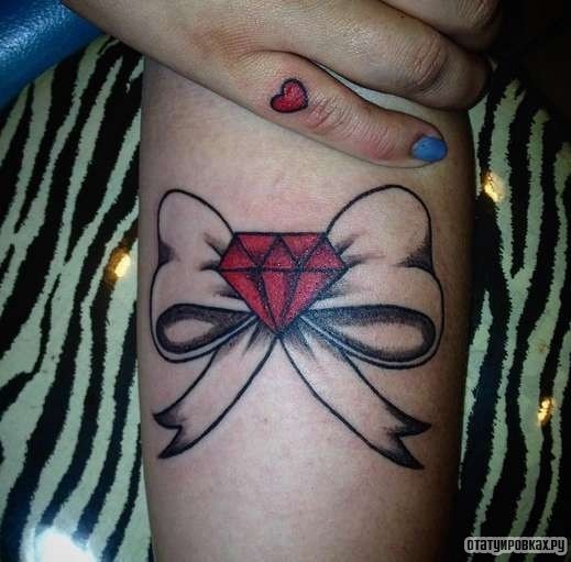 Фотография татуировки под названием «Бантик с красным алмазом»