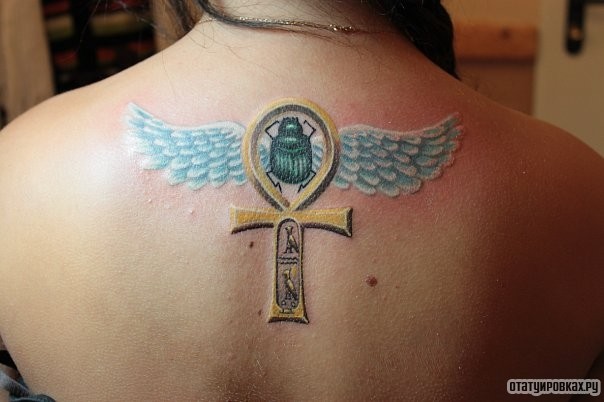 Фотография татуировки под названием «Жук с крыльями и сомвол»