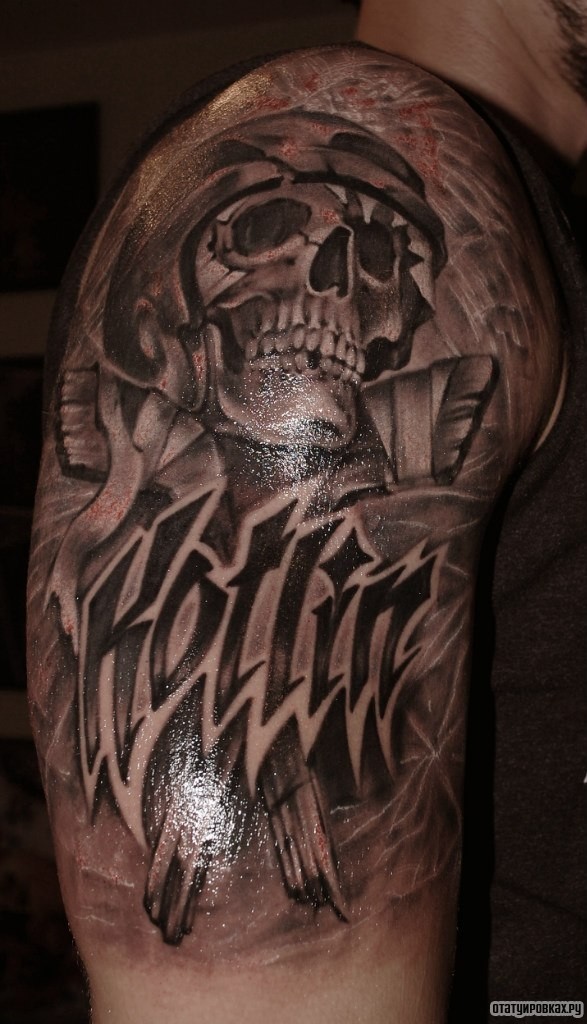 Фотография татуировки под названием «Череп в каске и надпись»