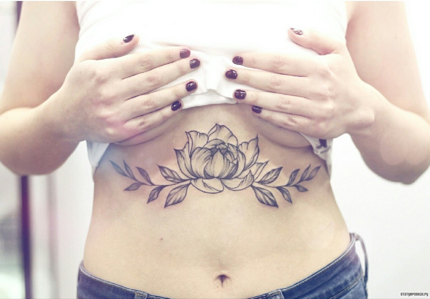 Фотография татуировки под названием «Цветок и ветки с листьями»