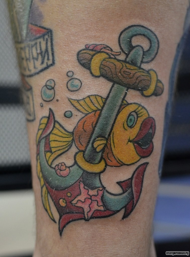 Фотография татуировки под названием «Золотая рыбка и якорь мультяшная тату»