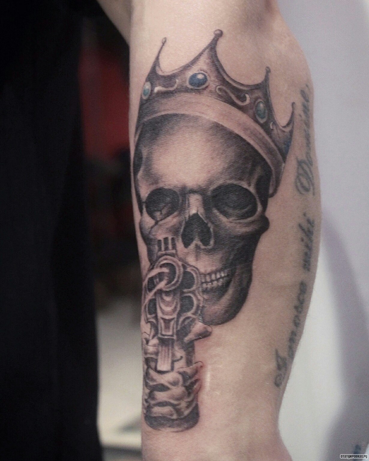 Фотография татуировки под названием «Череп в короне с пистолетом»