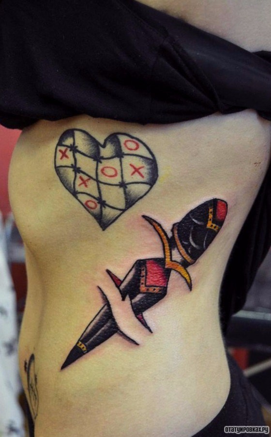 Фотография татуировки под названием «Сердце с крестиками ноликами и кинжал»