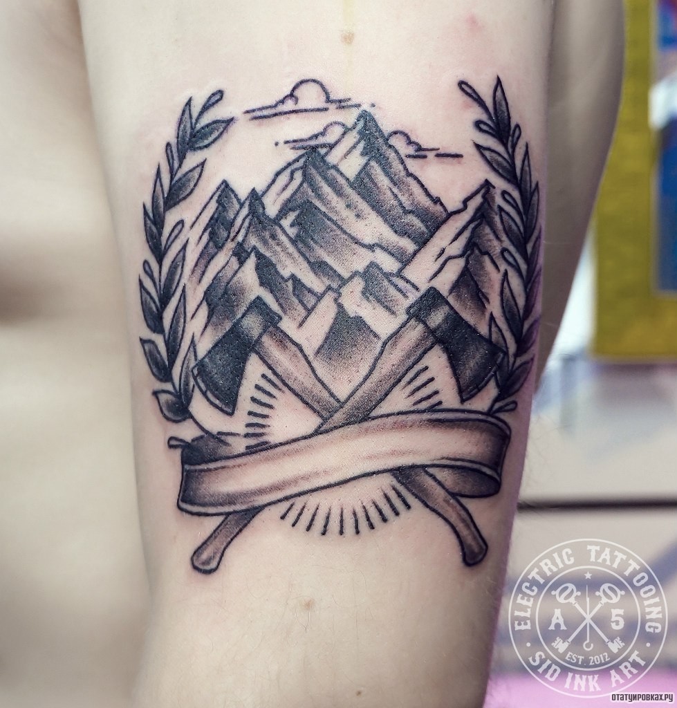 Фотография татуировки под названием «Два топора на фоне гор»