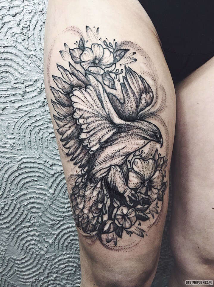 Фотография татуировки под названием «Птица в полете на фоне цветов»